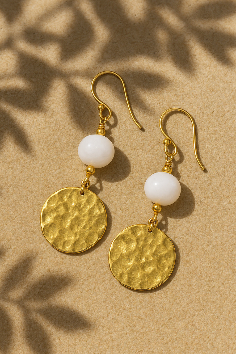 Shakti gold disk and moonstone earrings in warm golden light